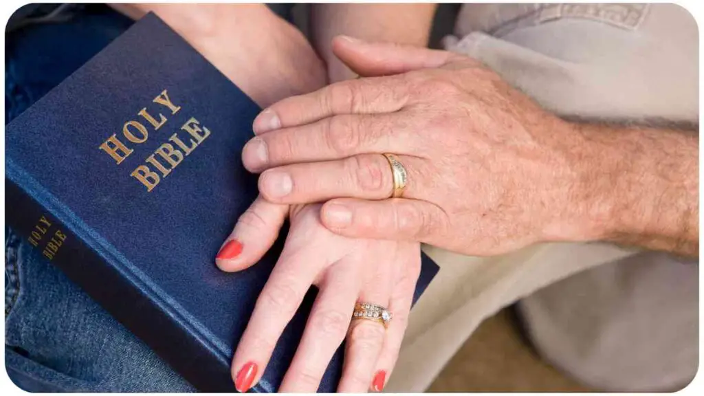 a couple holding hands over a bible