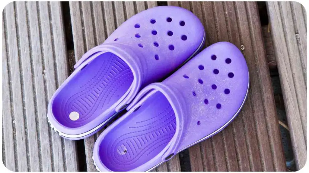 a pair of purple crocs sitting on a wooden floor