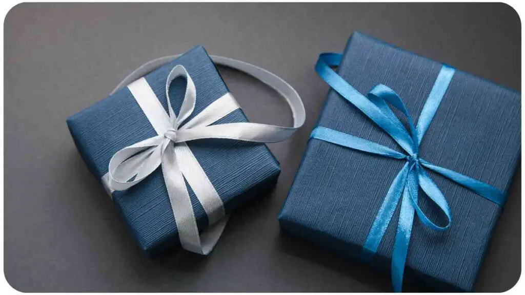 two blue gift boxes with white ribbons on a gray background