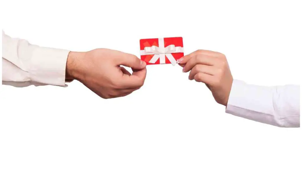 two hands holding a red gift card over a white background