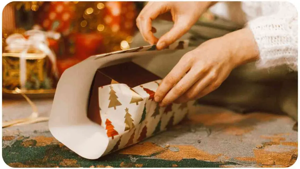 a person is wrapping a Christmas gift in a paper bag.