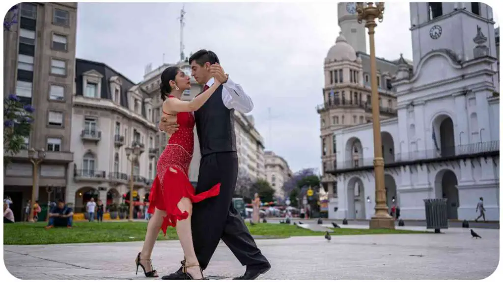a person and another person dressed in red are dancing in the middle of a city square.