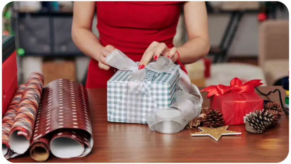 a person in a red dress is wrapping presents on a table