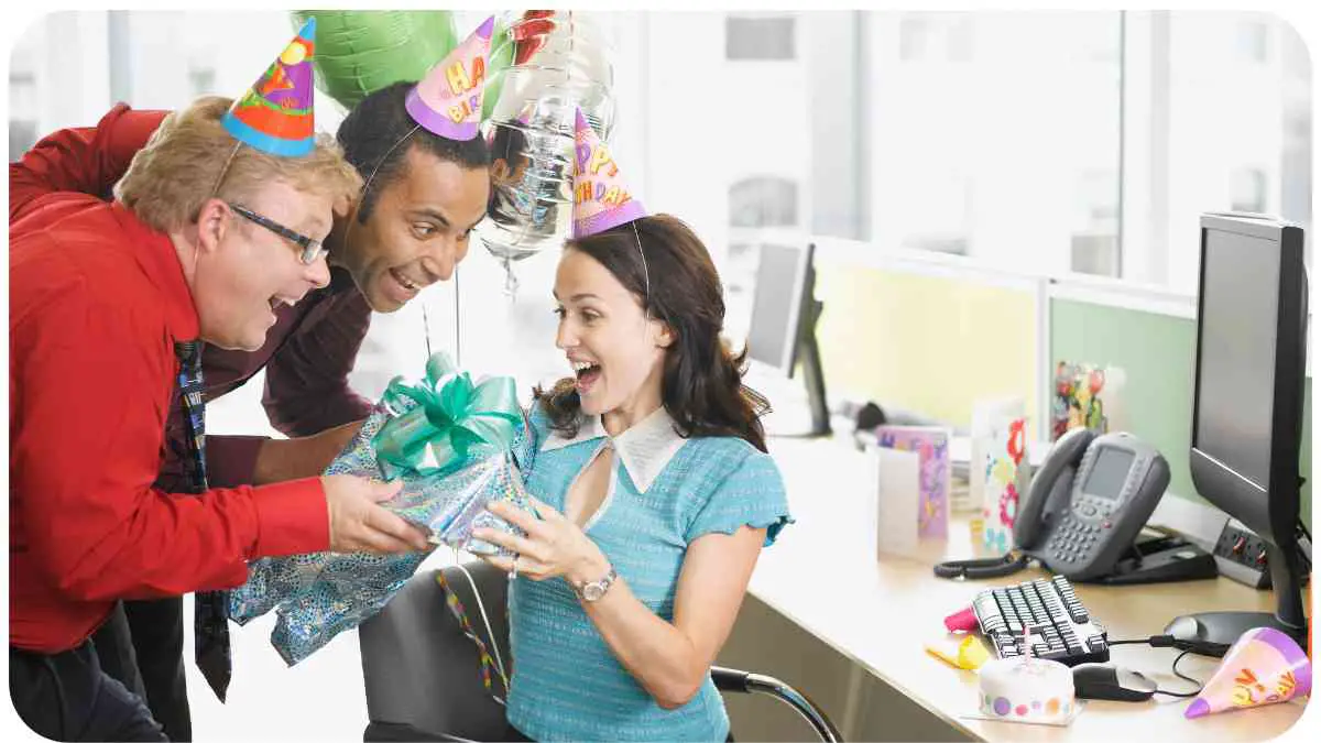 a group of people in an office celebrating a birthday