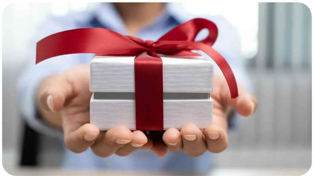 a person holding a gift box with a red ribbon